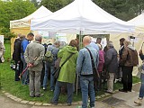 Besucher am Stand unter einem Zeltschirm